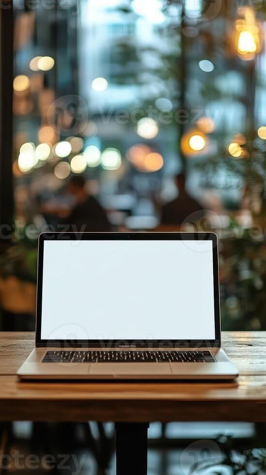Laptop sits on a wooden table in a cozy cafe with blurred background and warm lighting photo