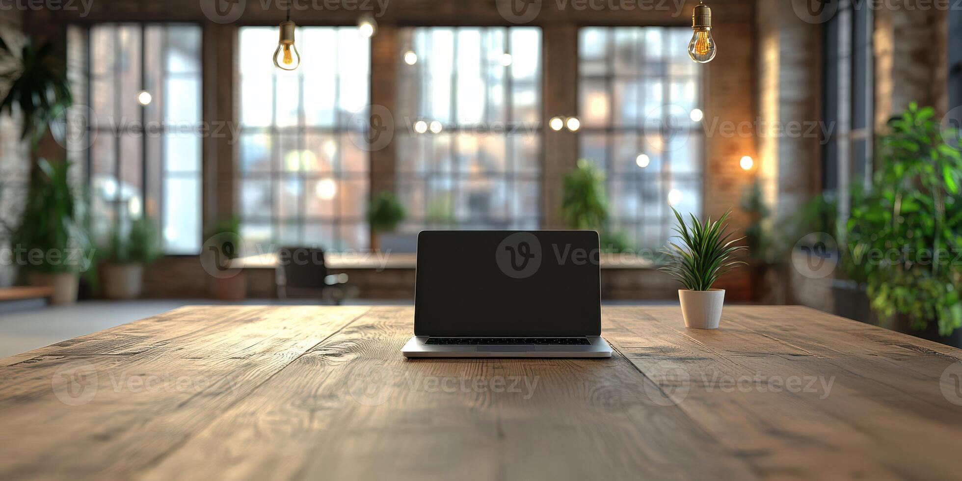Modern workspace featuring a laptop and greenery in a spacious industrial loft during daylight photo