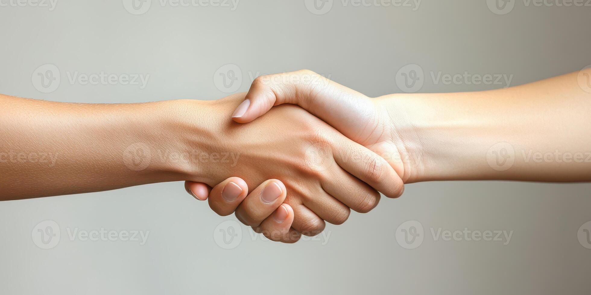 Handshake between two people symbolizing agreement and teamwork in a neutral setting photo