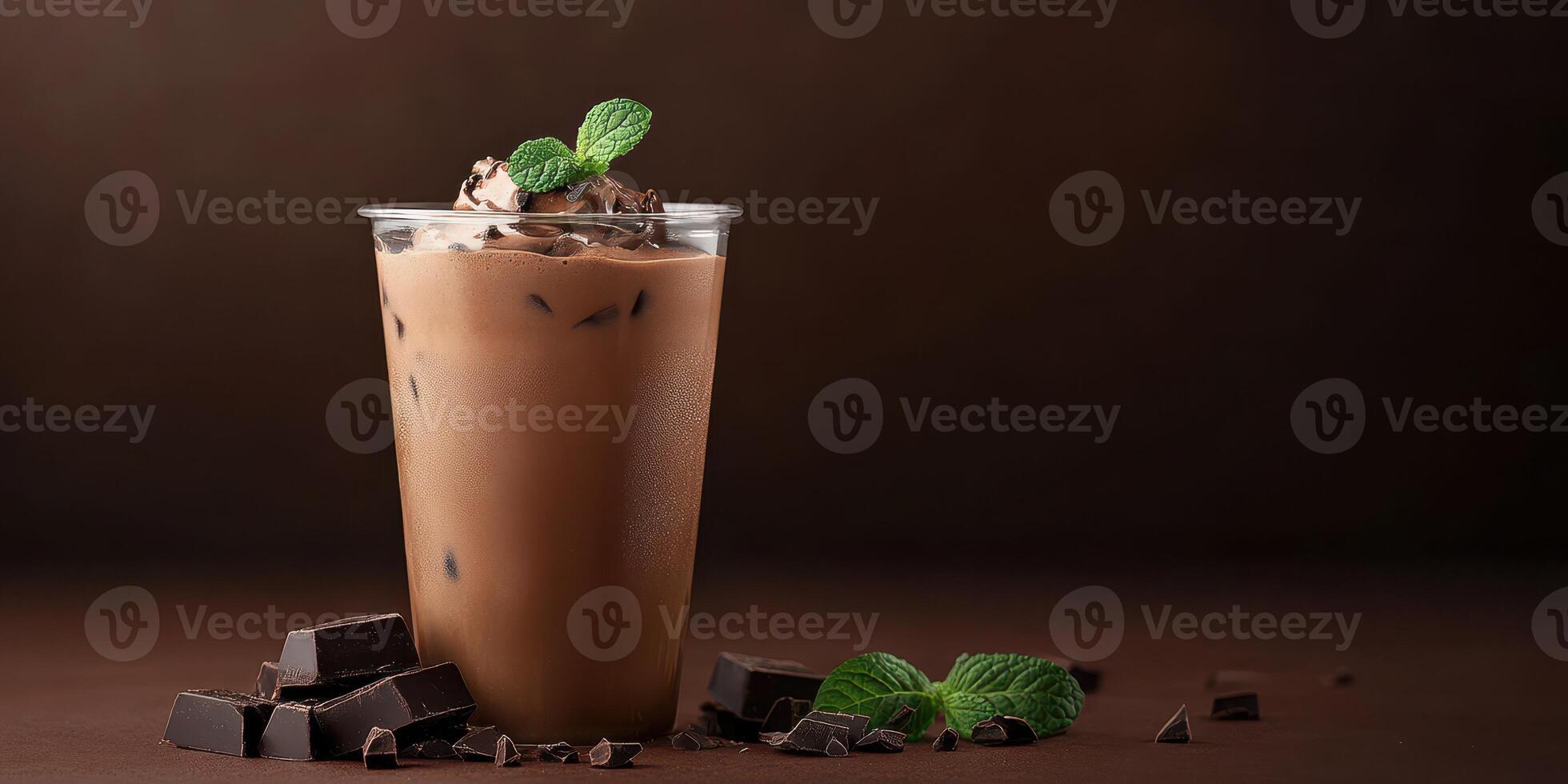 Delicious iced chocolate drink topped with mint leaves and chocolate shavings on a dark background photo