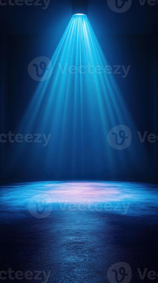 Bright blue spotlight illuminates an empty stage in a dark room, creating a captivating atmosphere for performance photo