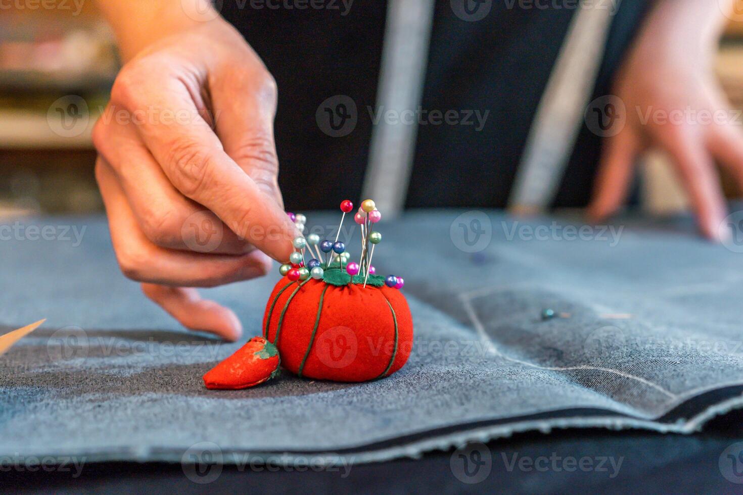 Fashion designer putting pins into a pincushion photo