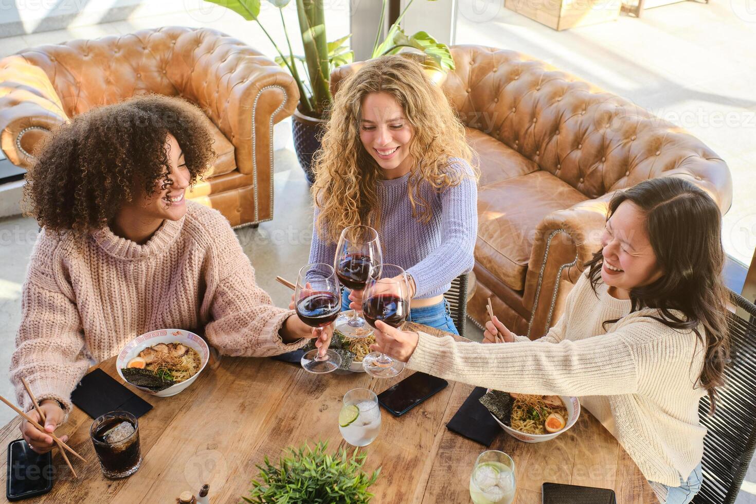 Cheerful diverse women having dinner photo
