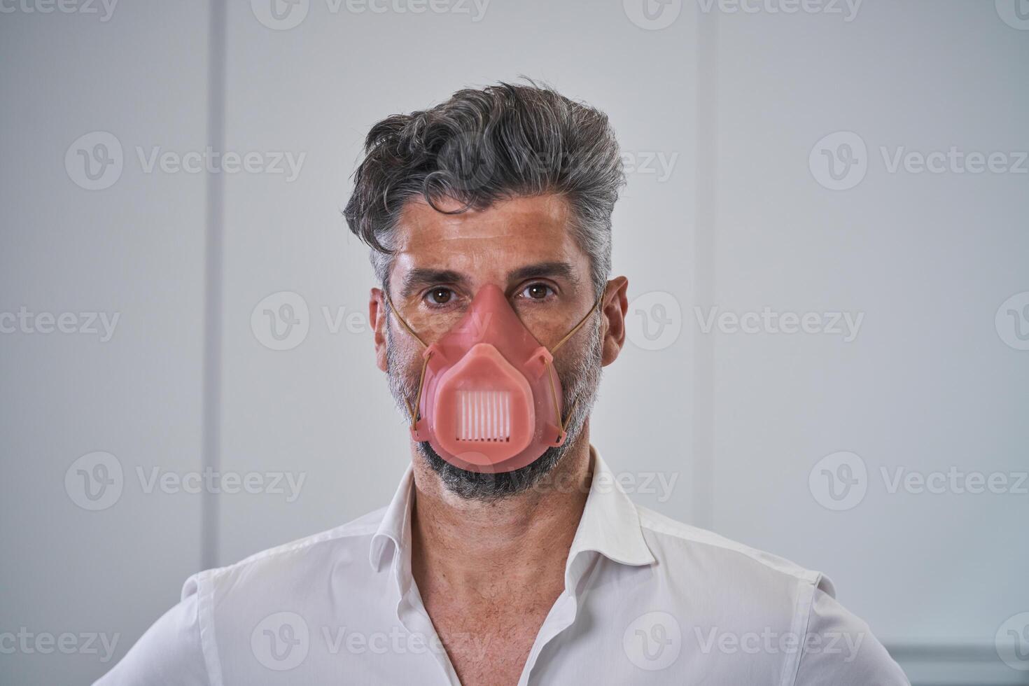 Serious adult male in protective mask looking at camera photo