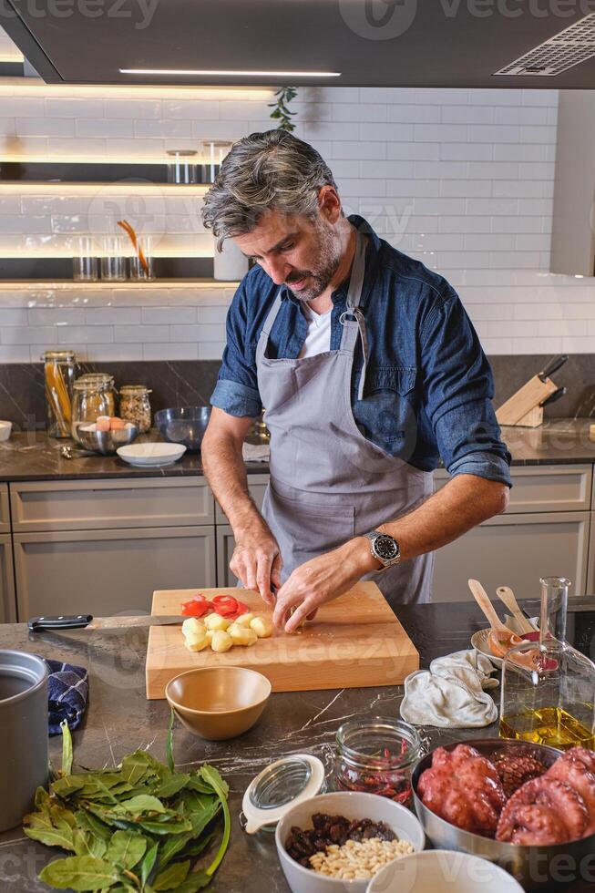 Mature man cooking in kitchen photo