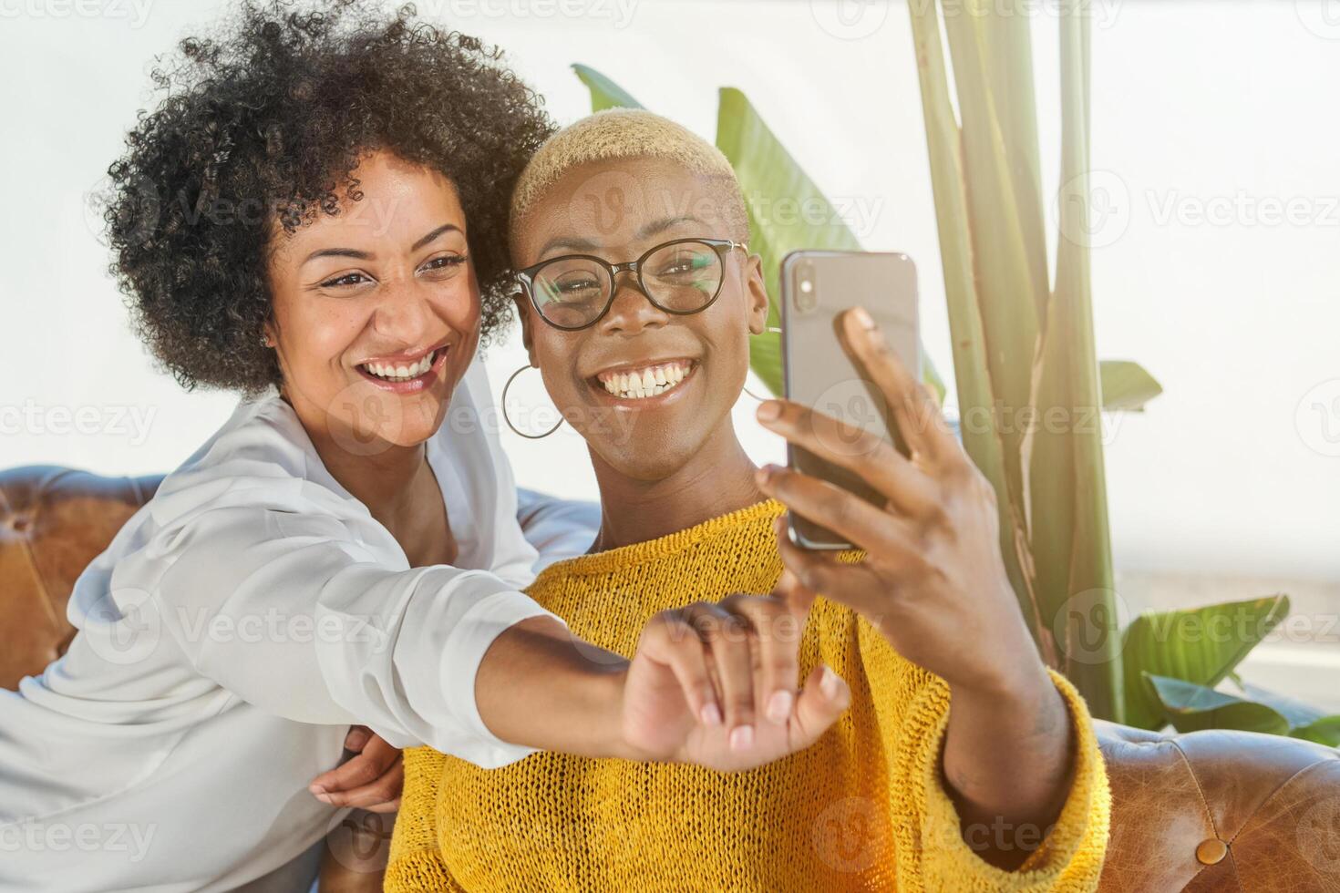 Smiling multiracial women taking selfie on smartphone photo