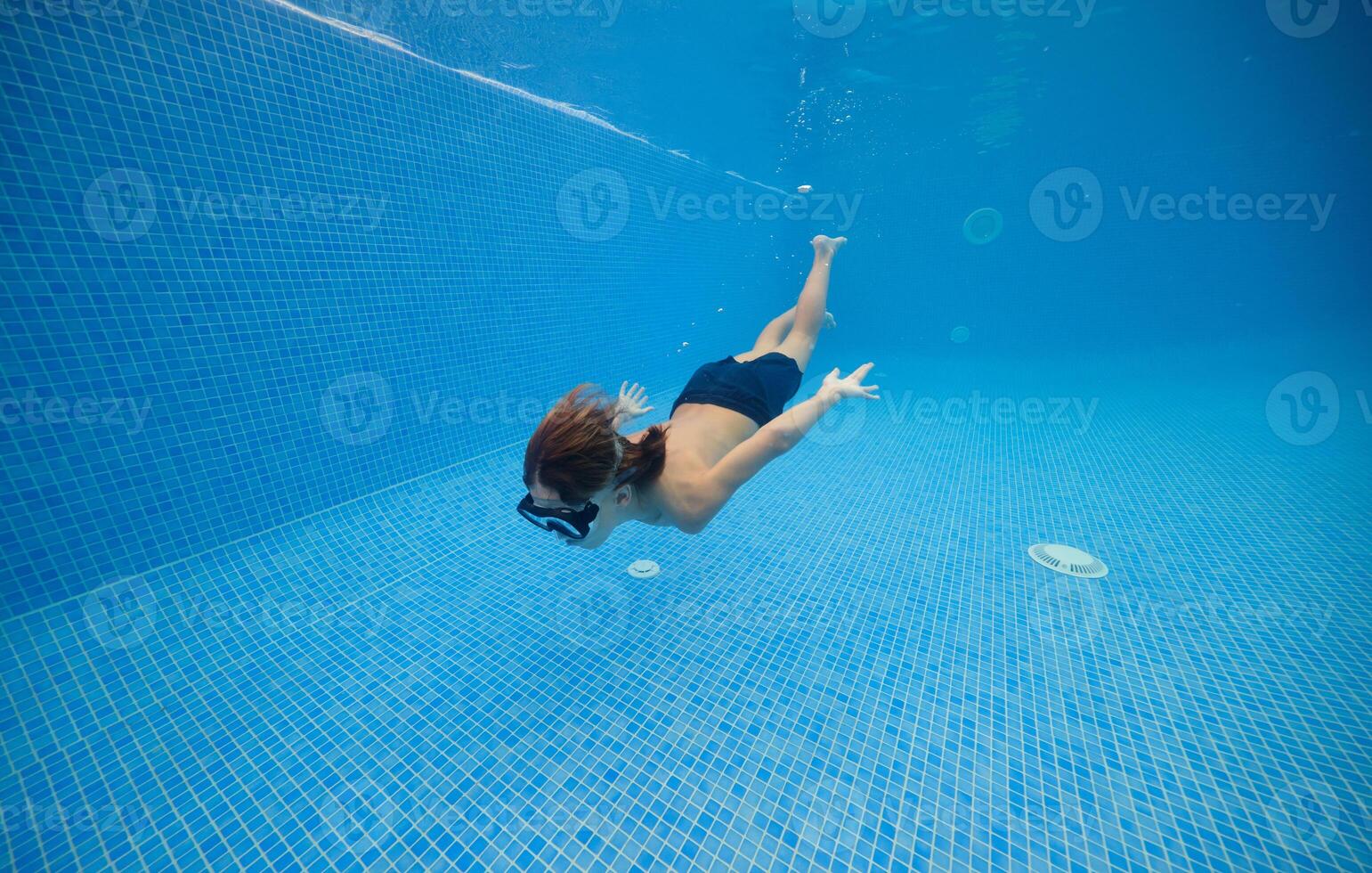 Boy moving in blue swimming pool photo