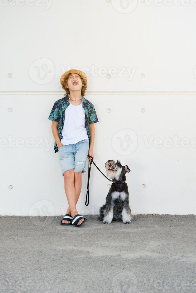 Stylish boy screaming with dog on sidewalk photo