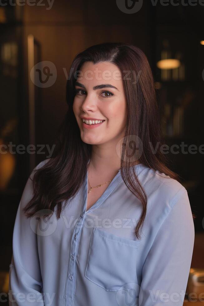Smiling young woman in blouse looking at camera photo