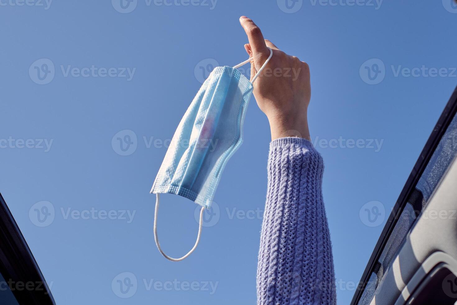 Crop faceless woman outstretching hand with face mask photo