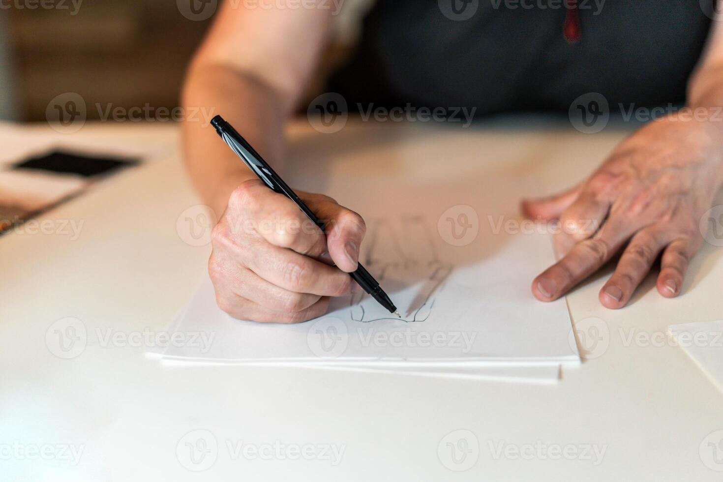 Close-up of a fashion desinger drawing with a pencil. photo