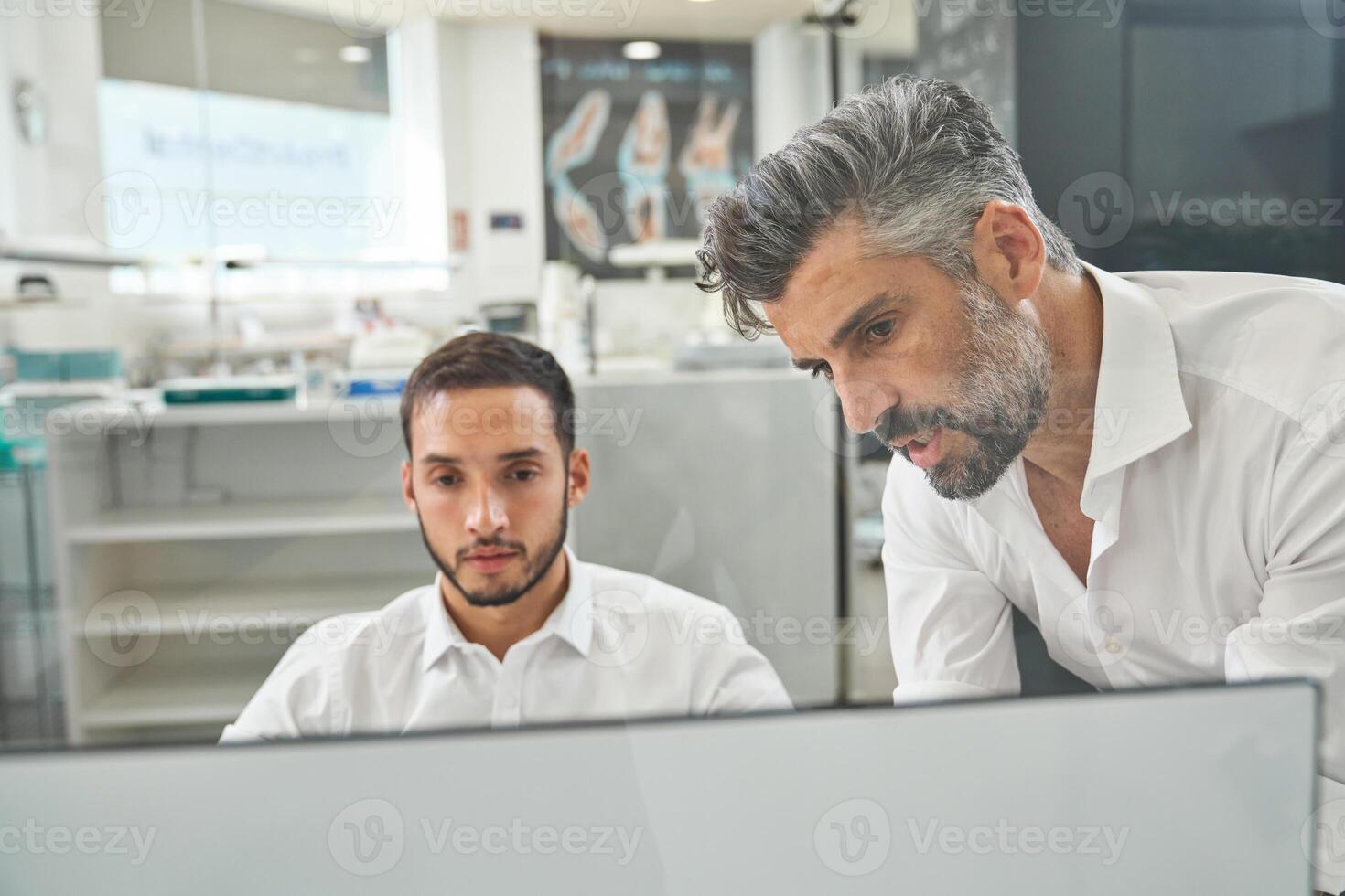 Concentrated colleagues working on computer photo