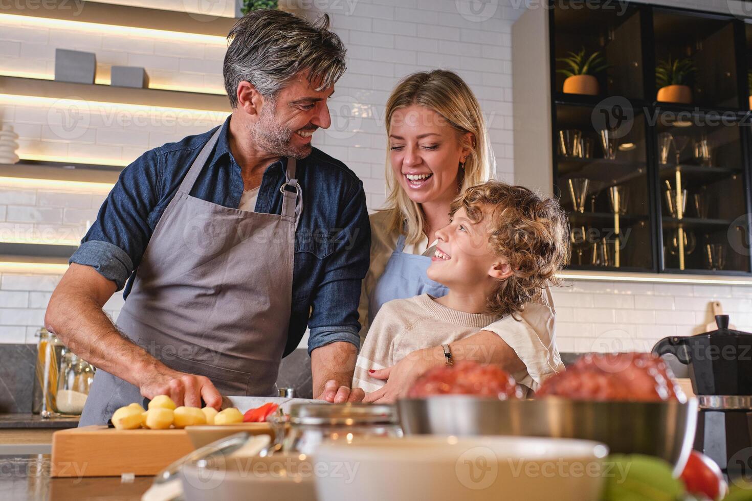 Happy couple teaching son cooking photo