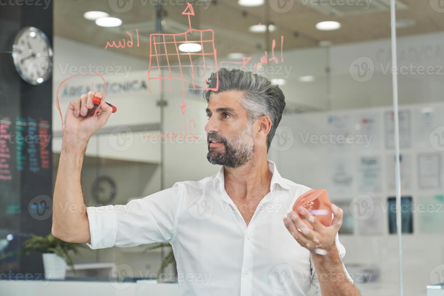 Concentrated engineer with model of respirator taking notes photo