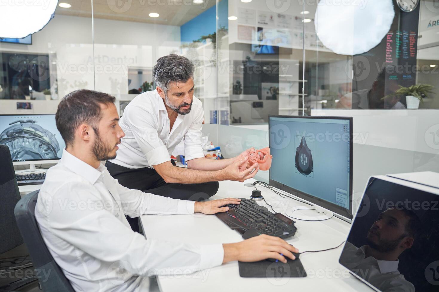 Men designing respirator on computer photo