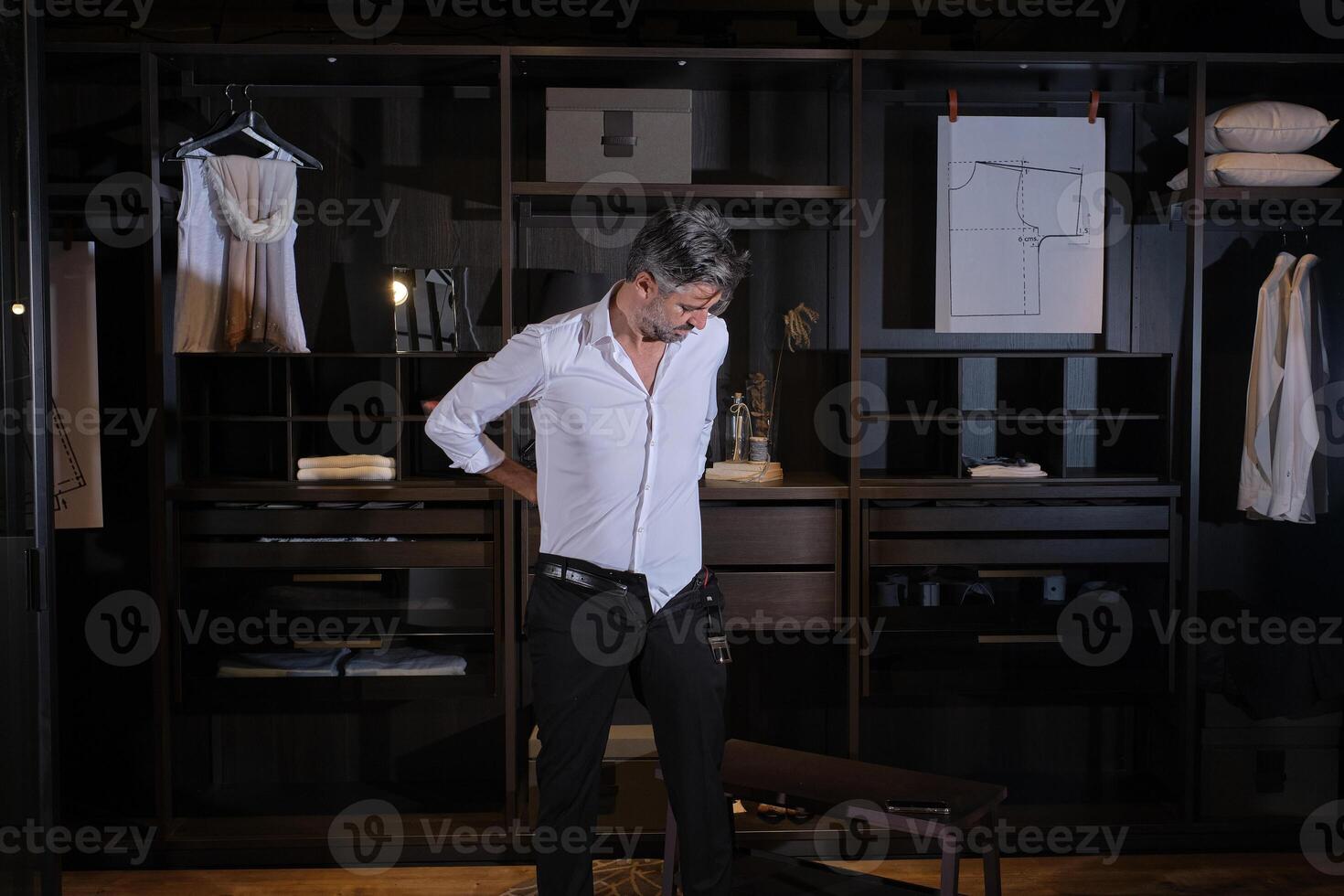 Mature man dressing in trousers at home photo