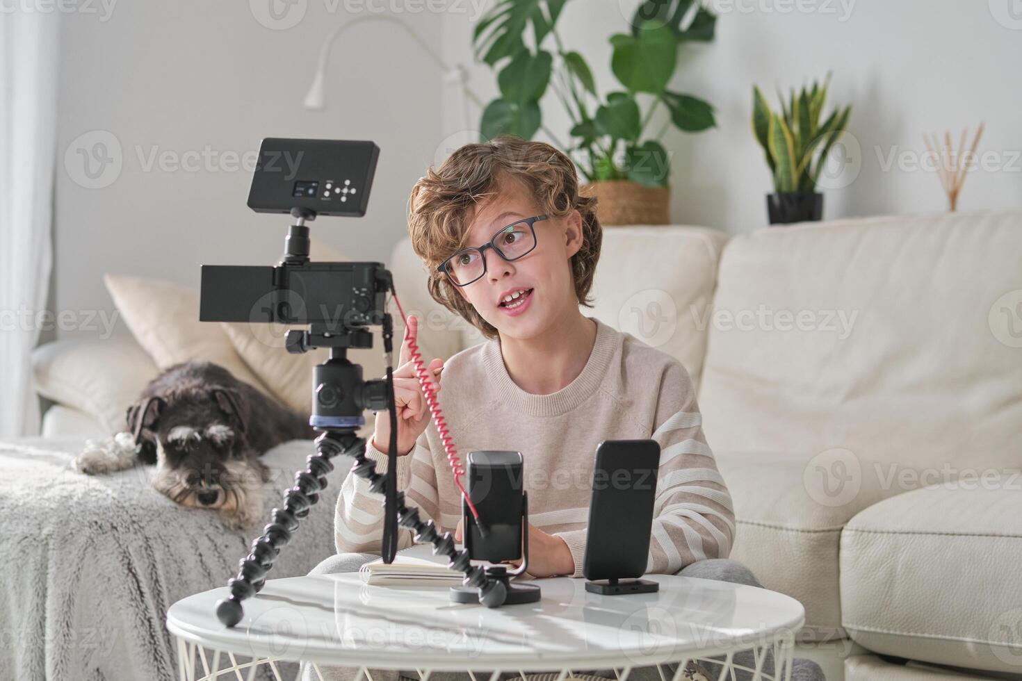 Boy pointing up and talking while shooting at home photo