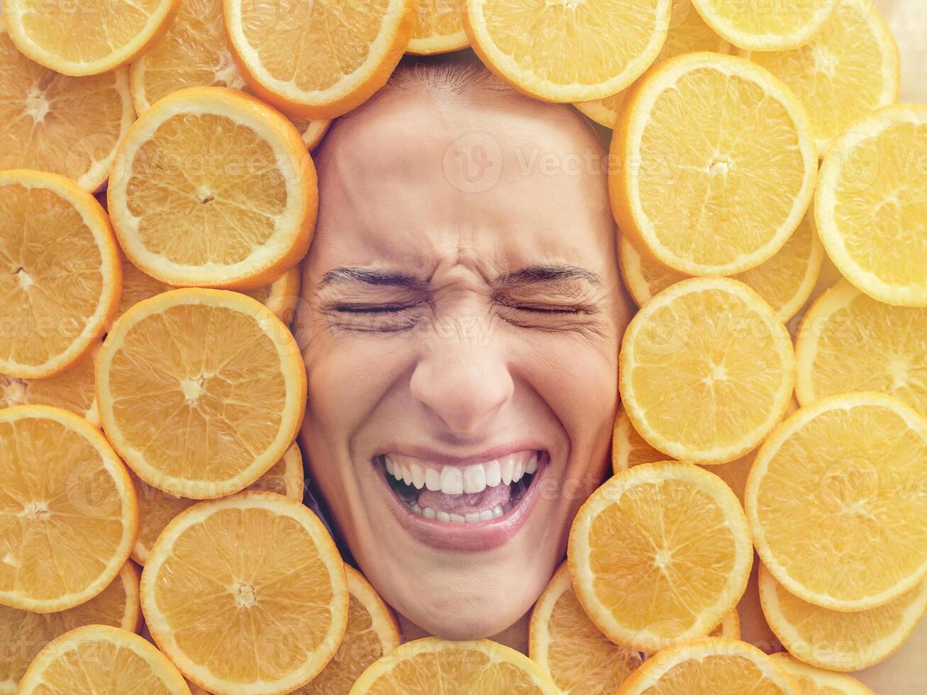 Discontent woman immersed in pile of cut oranges photo