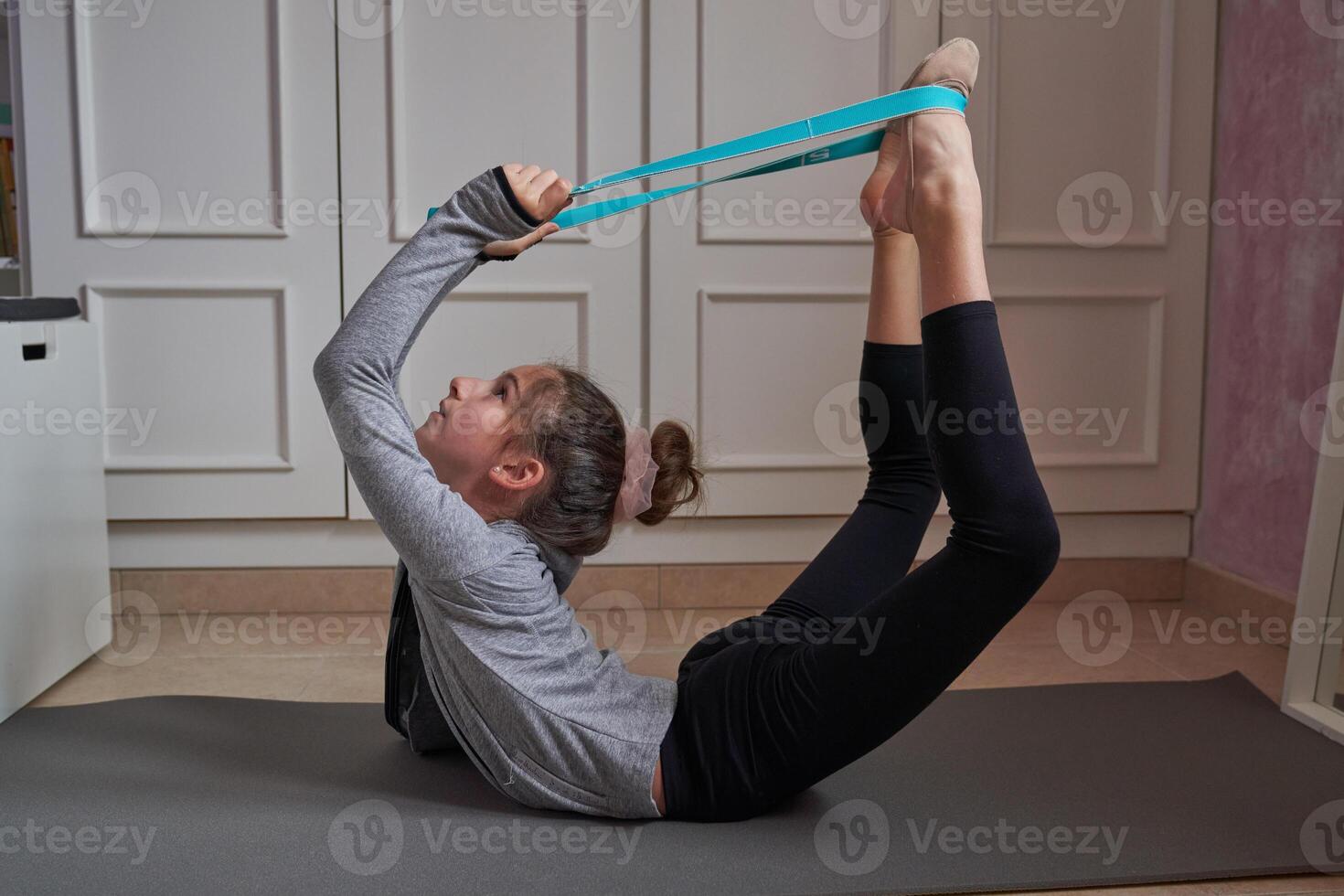 Child exercising with resistance band at home photo