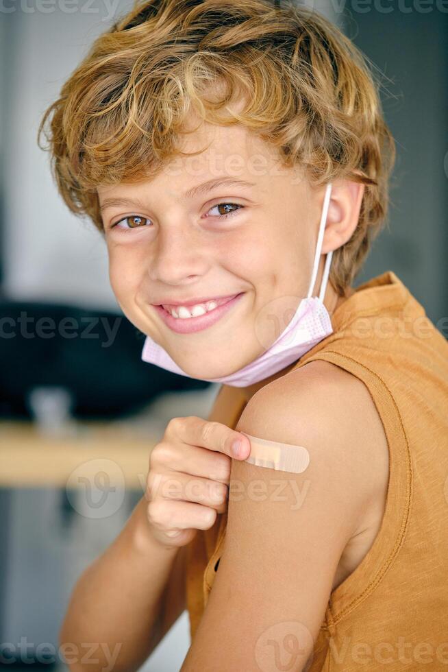 Cheerful boy with patch and medical mask photo