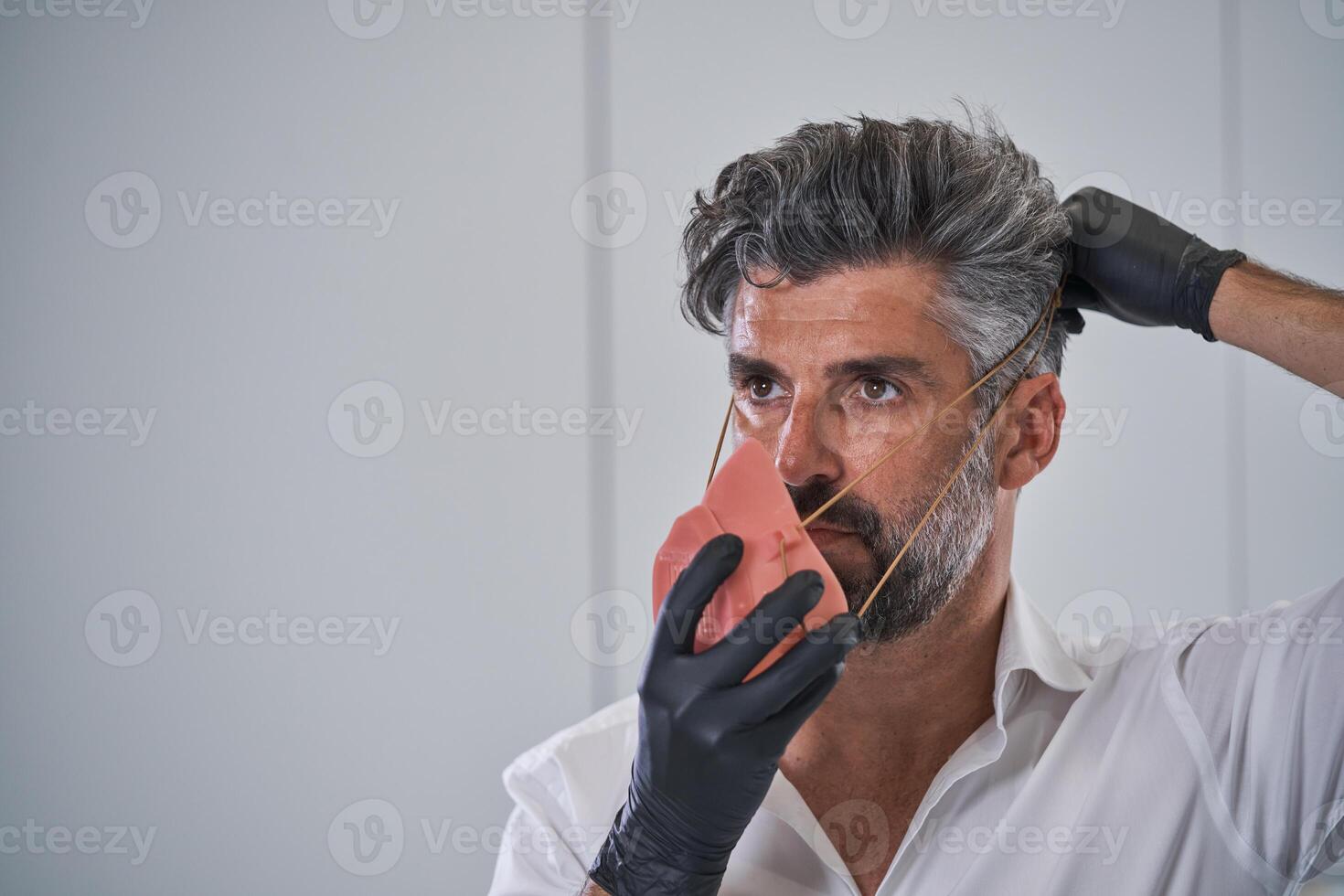 Mature man putting on protective mask from coronavirus pandemic photo