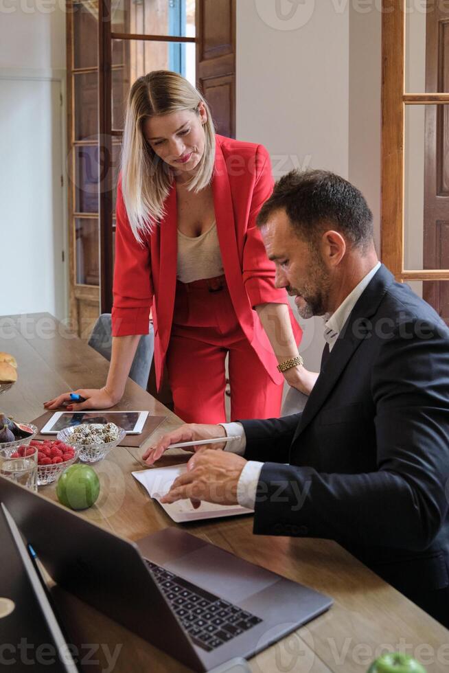 Smiling female manager working on project with male colleague photo