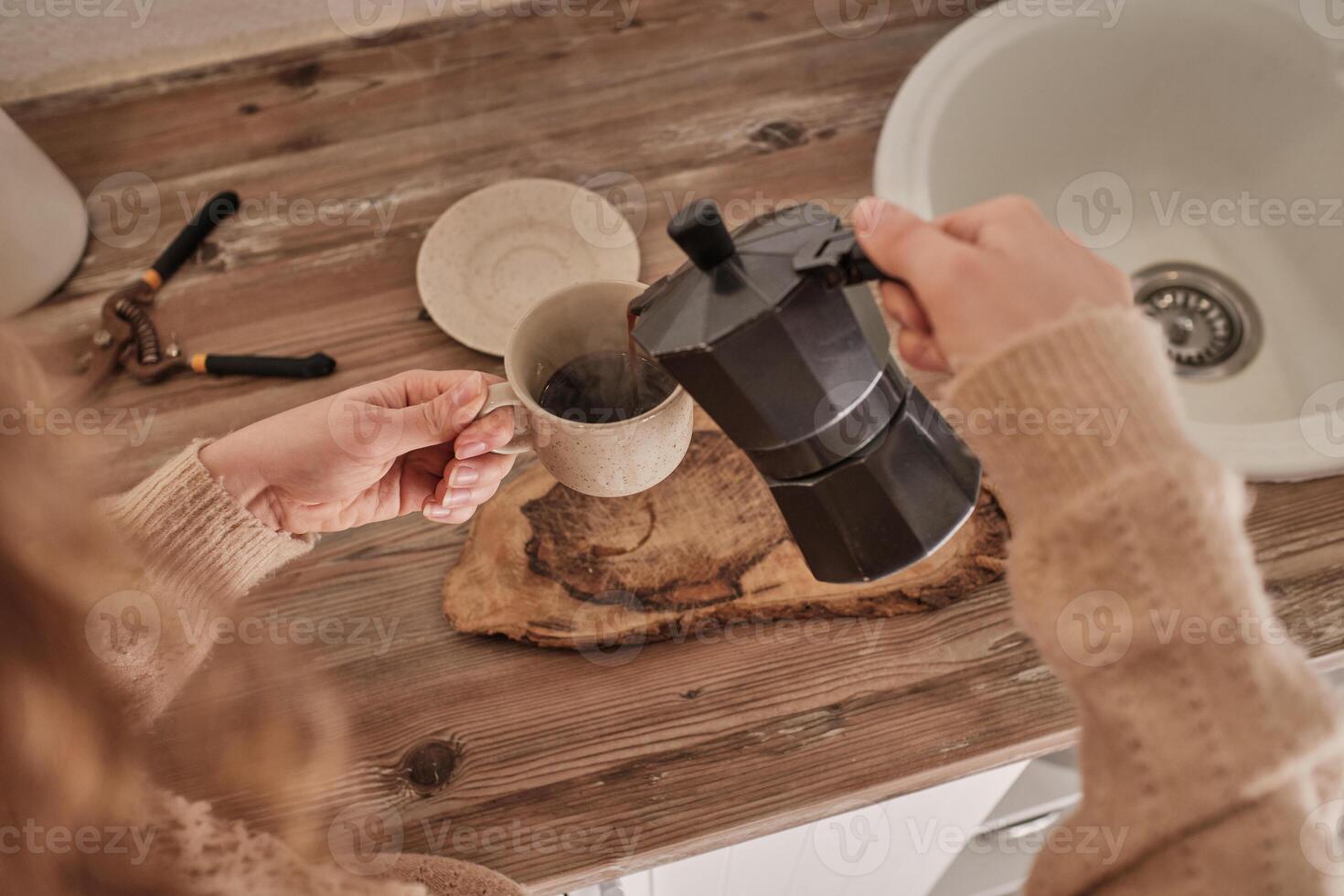Unrecognizable woman making tasty coffee with moka pot photo