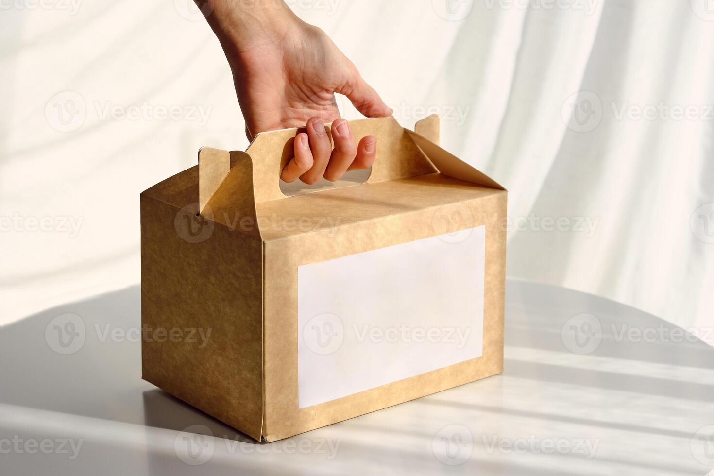Woman taking carton box placed on table photo