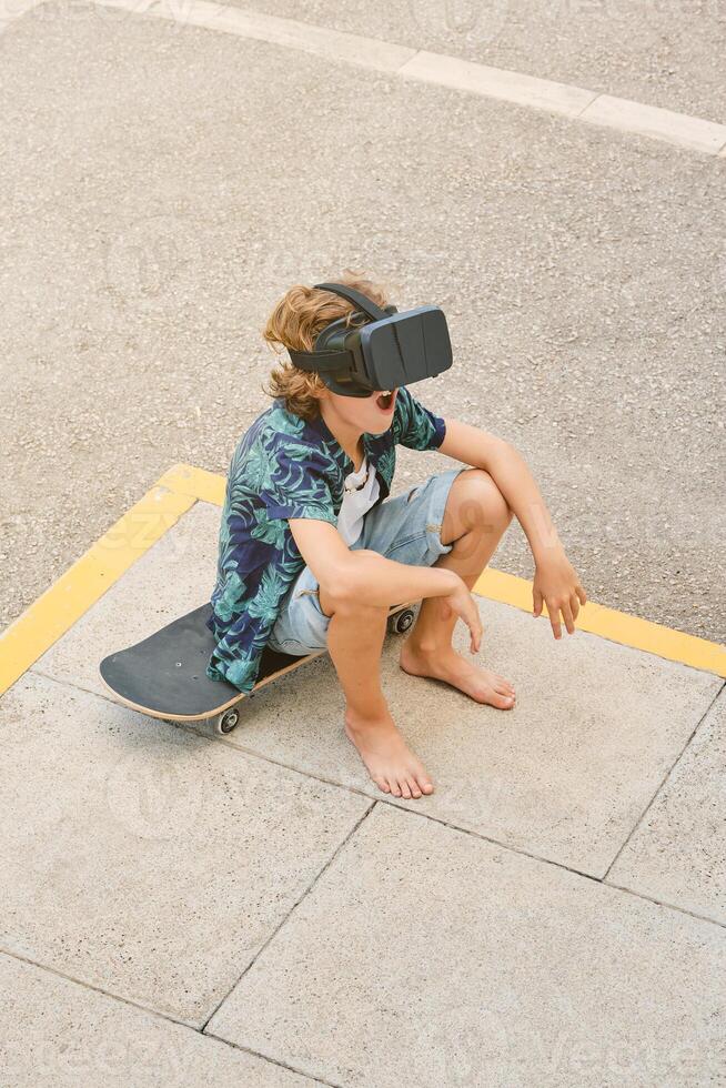 Boy in VR headset sitting on skateboard photo
