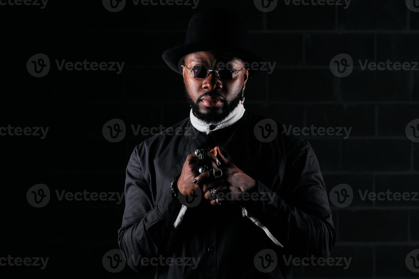 Stylish ethnic man looking at camera in black studio photo