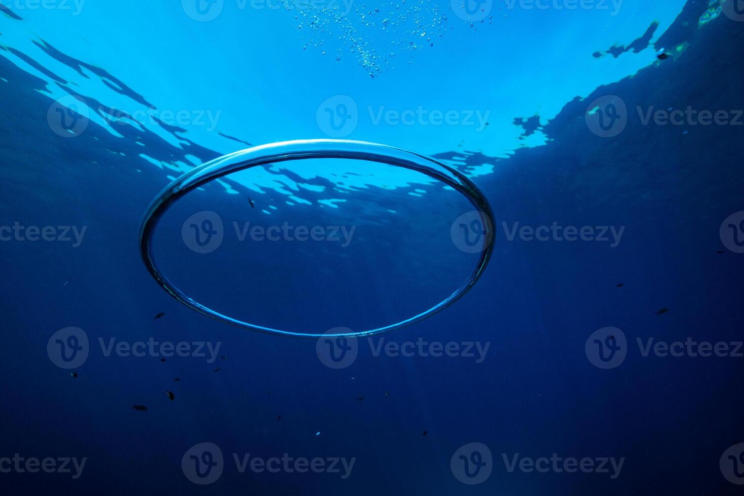 Ring shaped toroidal bubble under blue sea water photo