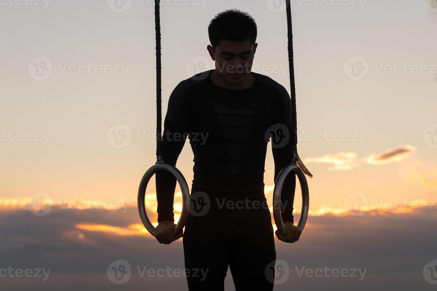 Sportsman training on gymnastic rings. Young man in action. photo