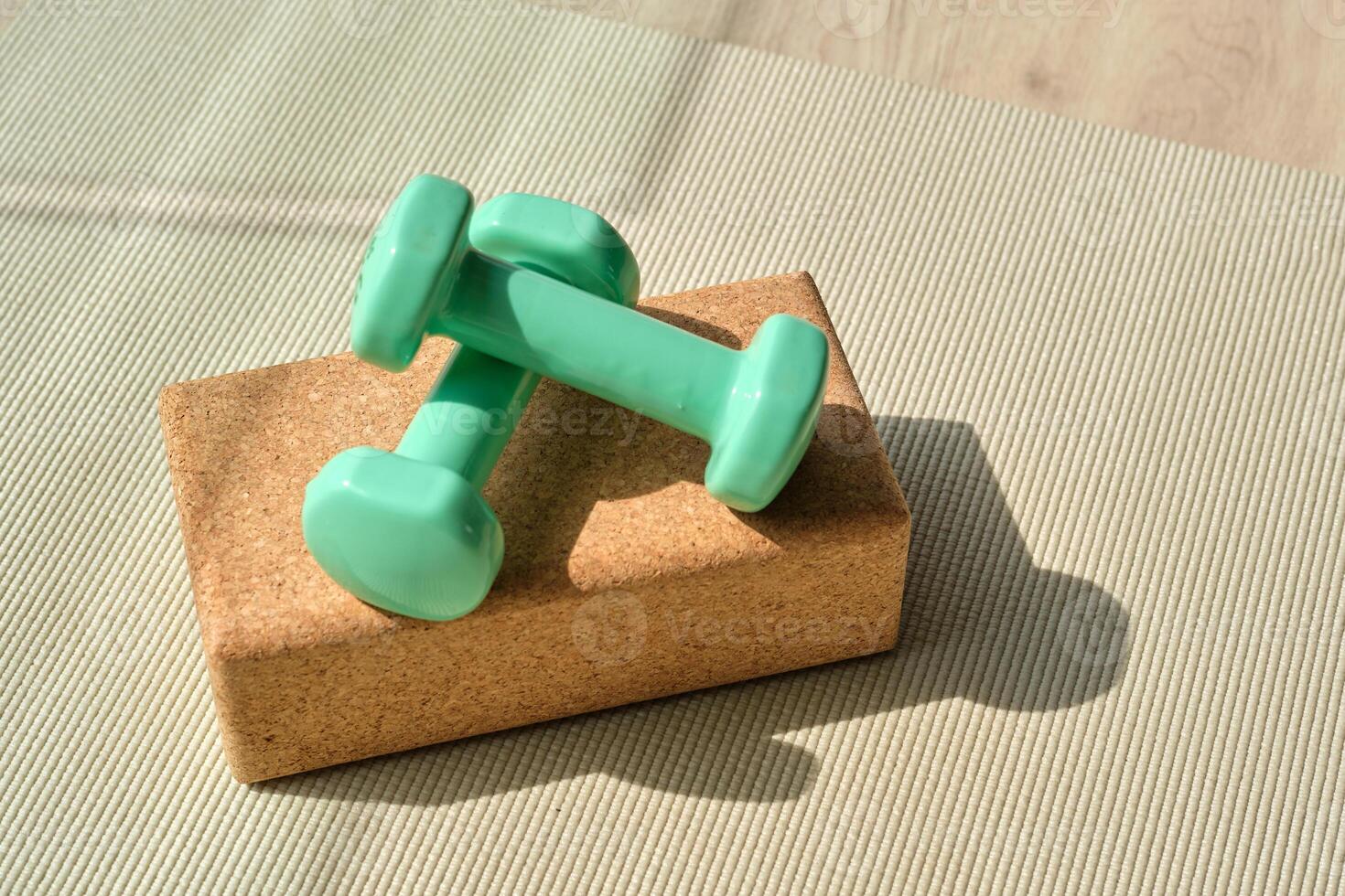 Dumbbells placed on yoga block on mat photo