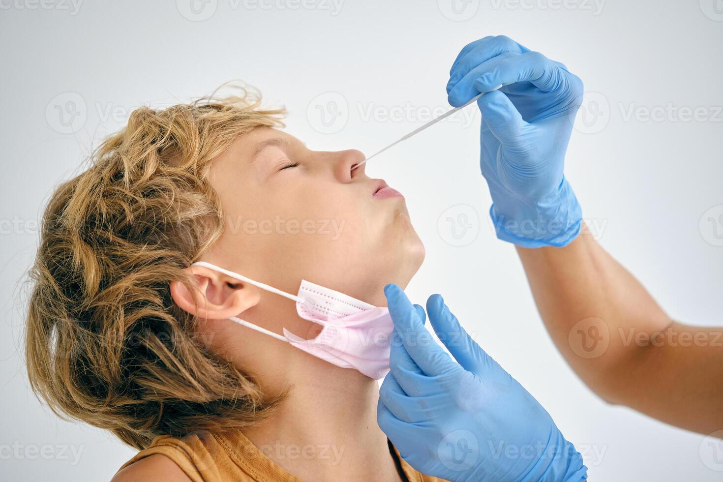 Crop nurse taking COVID test from boy in hospital photo