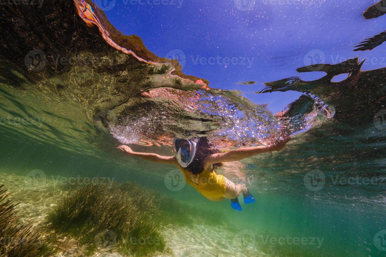 Unrecognizable child swimming in sea photo