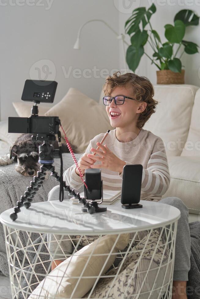 Boy laughing while recording for blog at home photo