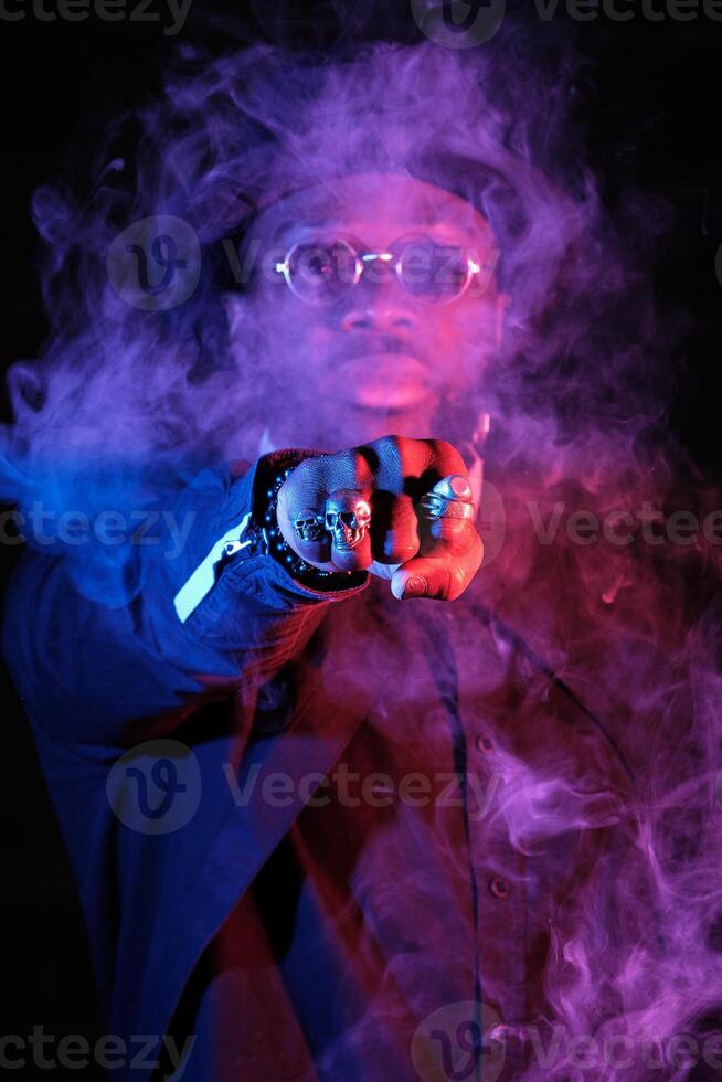 Serious ethnic man punching through vapor photo