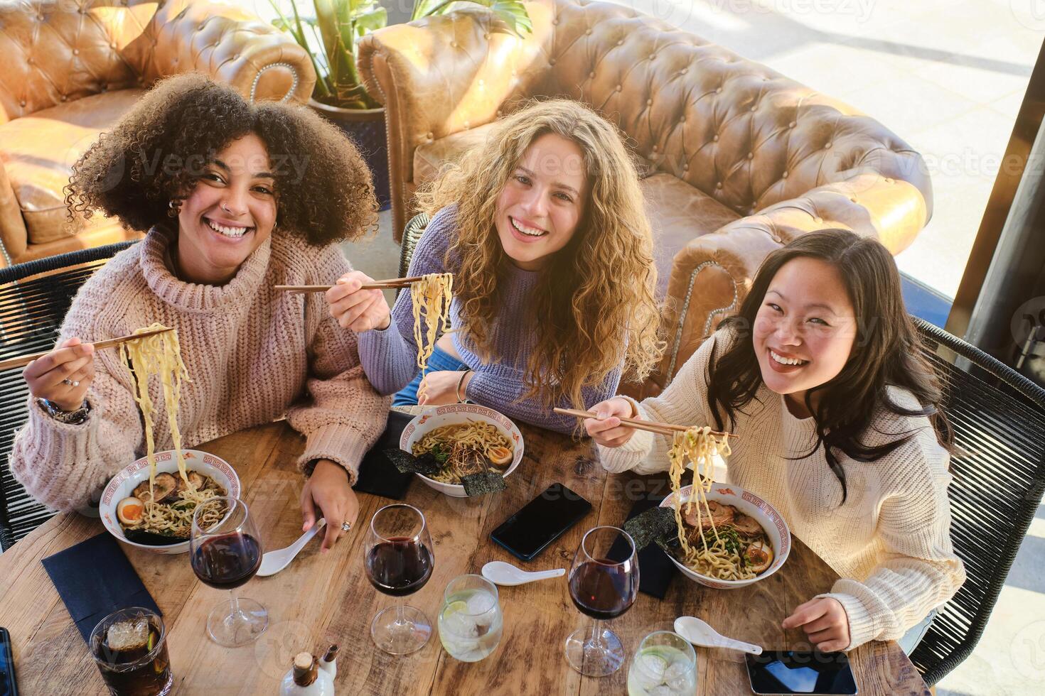 Cheerful multiracial female friends enjoying time in restaurant photo