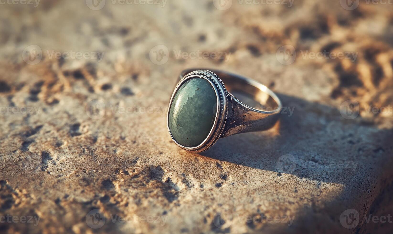 A green stone ring is on a stone surface photo