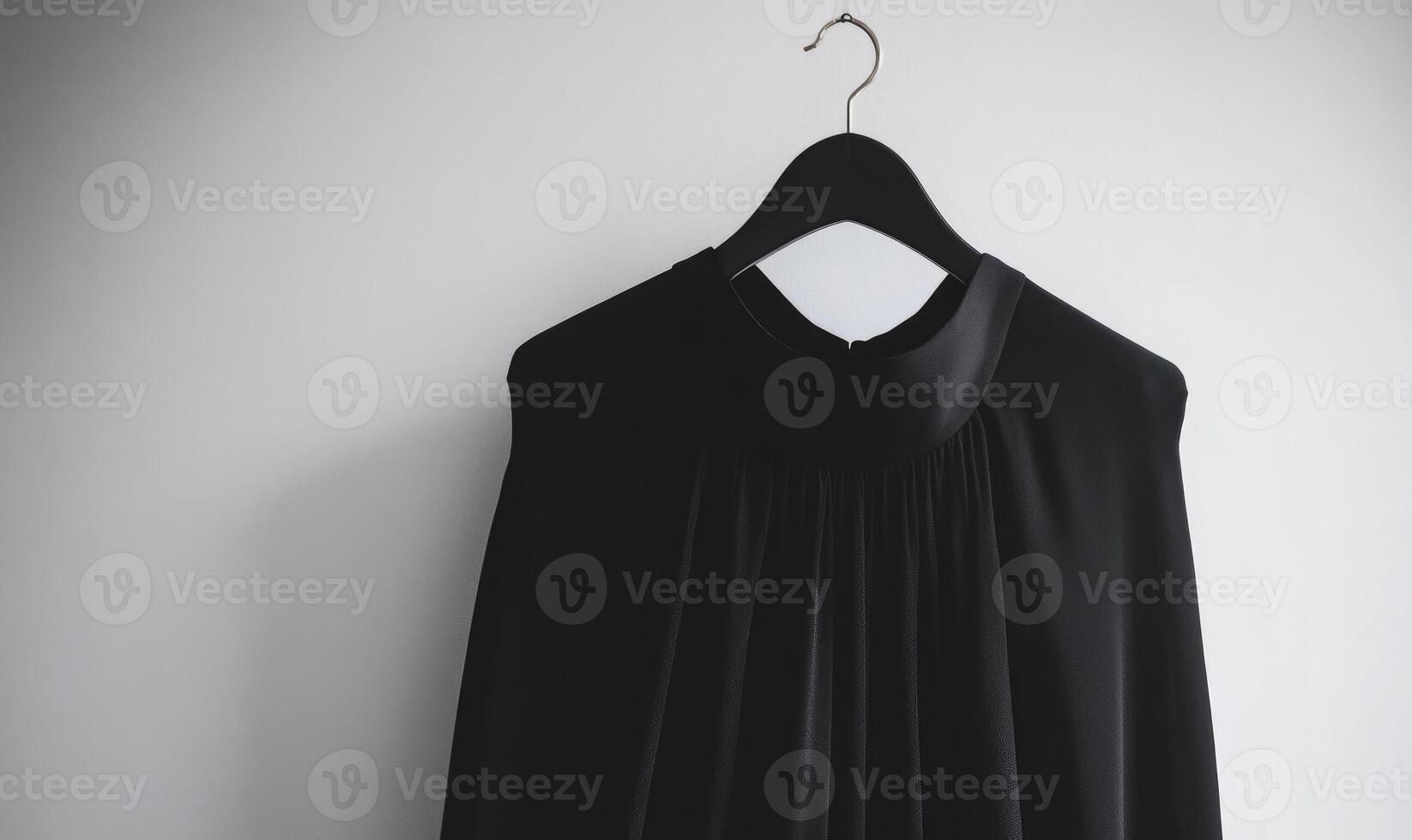 A black dress is hanging on a hanger, gray background photo