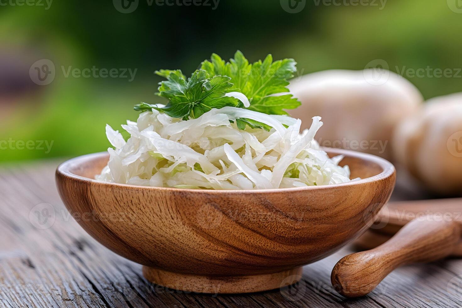 Wooden bowl full of sauerkraut with parsley topping on rustic table photo