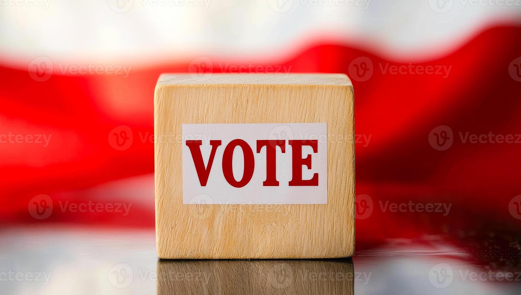 Vote block on table with flag background. A wooden block marked with the word vote rests on a reflective surface in front of a red and white flag backdrop. photo
