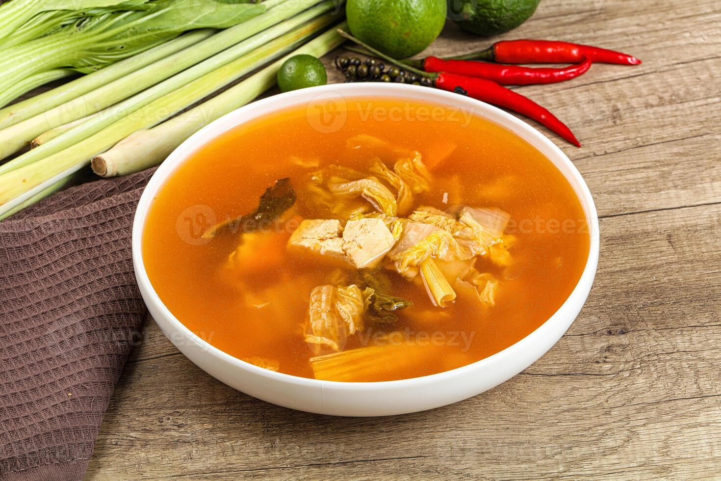 A bowl of soup with vegetables and a knife photo