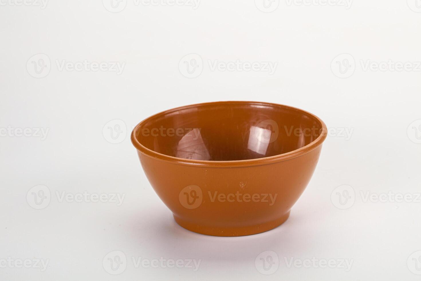 A small brown bowl on a white surface photo