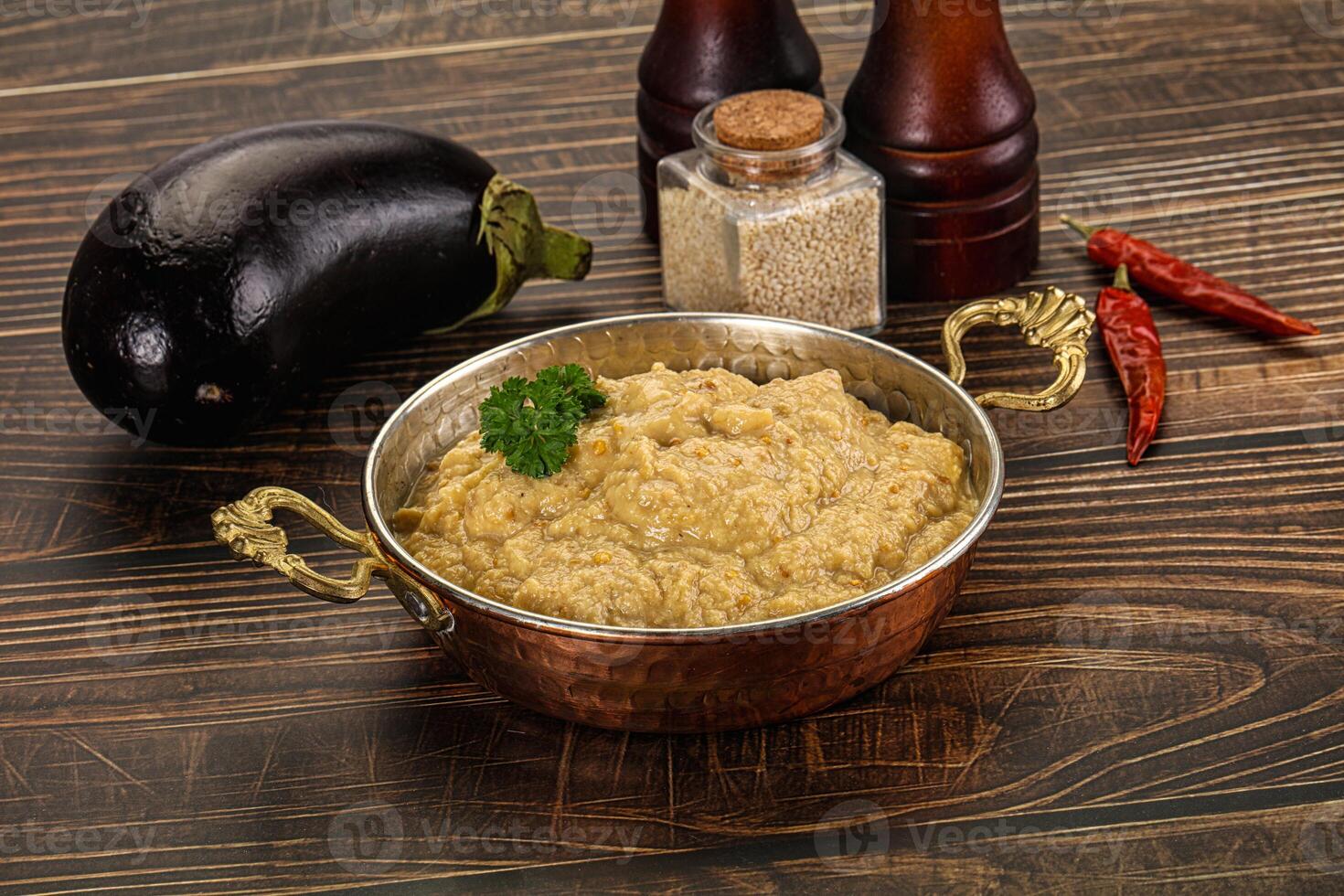 A bowl of rice and an eggplant on a wooden table photo