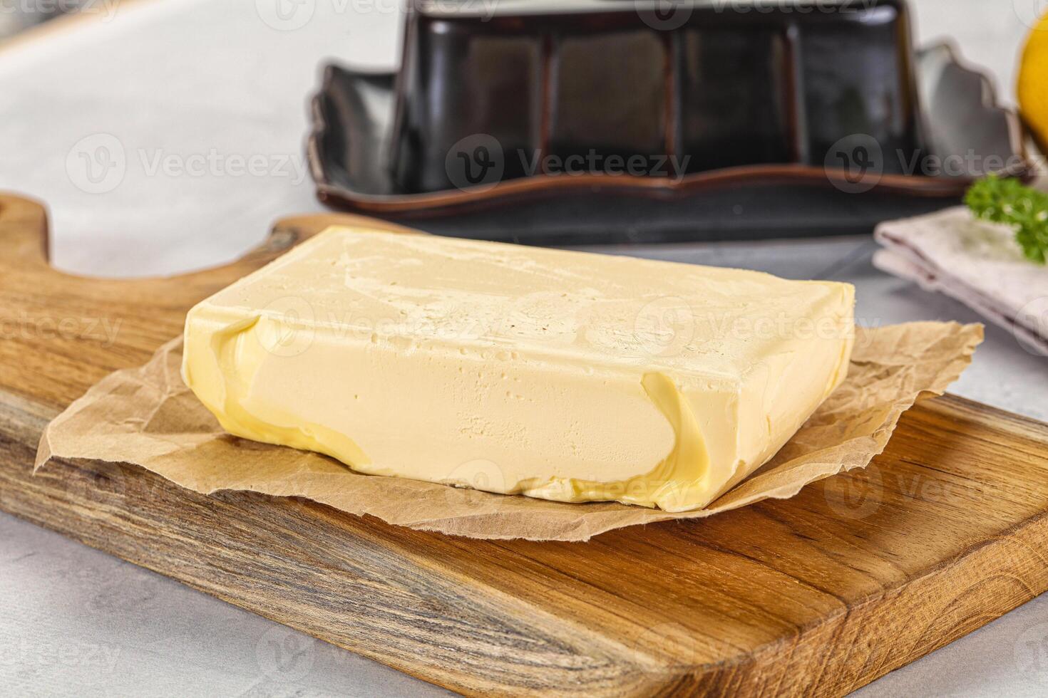 Butter on a cutting board with a knife and a lemon photo
