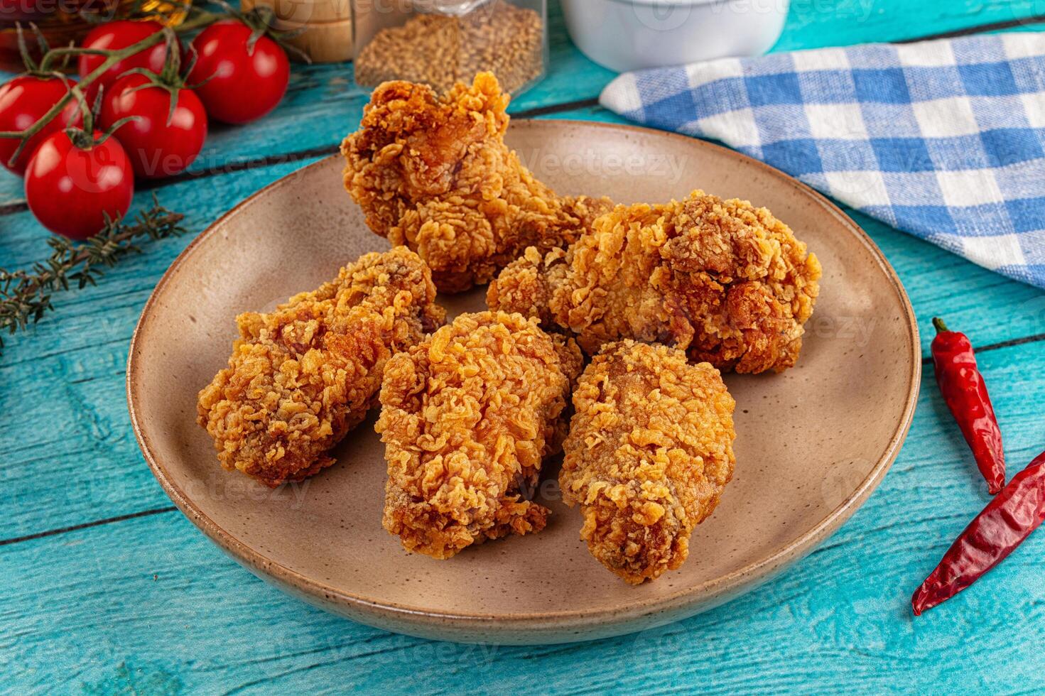 Fried chicken on a plate with tomatoes and spices photo