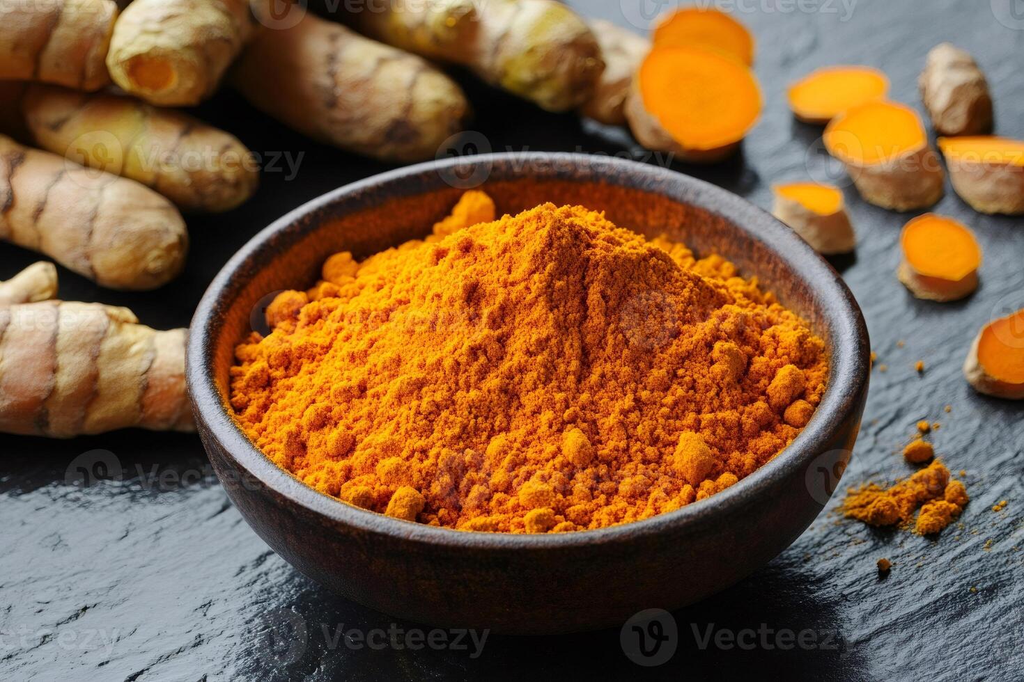 Turmeric powder in wooden bowl with fresh turmeric root.. . photo