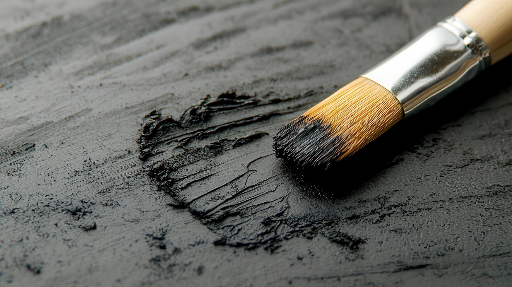 Close up of paintbrush applying thick black paint texture on a dark surface Artistic painting process photo