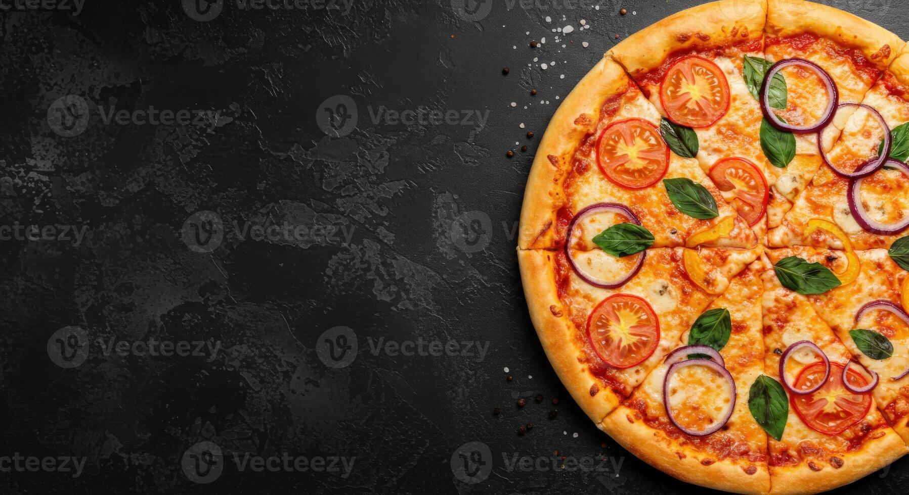 A pizza with tomatoes, basil and cheese on a black background photo